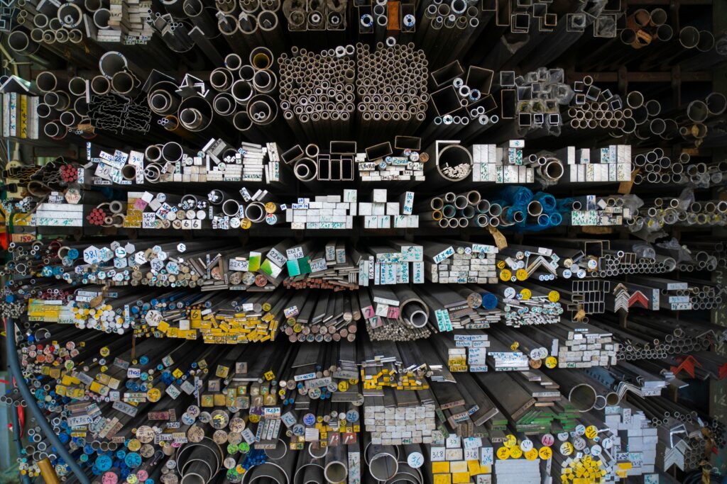 pexels photo 14838208 14838208 Diverse collection of stacked metallic pipes and rods in a warehouse display.