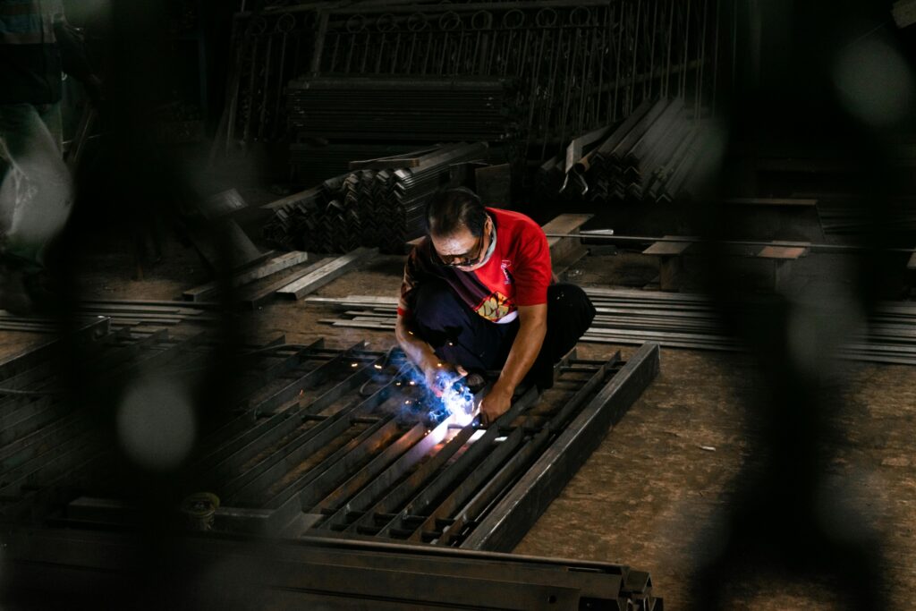 pexels photo 25525455 25525455 A focused welder in a workshop, working with steel and sparks flying.